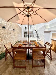 a table and chairs with an umbrella on a patio at Cor de Mar • Pátio • 2 Quartos • Centro Histórico in Peniche