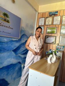 a woman standing next to a desk in a room at Carmela Haven Inn in Baler