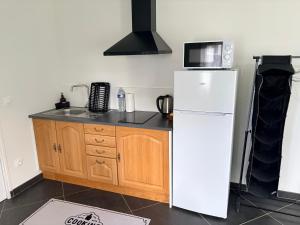 a kitchen with a white refrigerator and a microwave at Studio 2 - Loc Conciergerie in Trappes