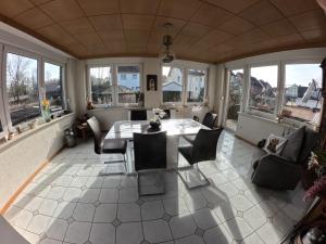 a living room with a table and chairs and windows at fewo-twete in Stadtoldendorf +4 photos