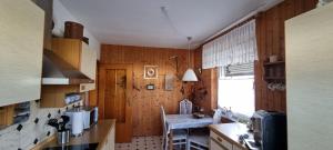 a kitchen with wooden walls and a table and a window at fewo-twete in Stadtoldendorf