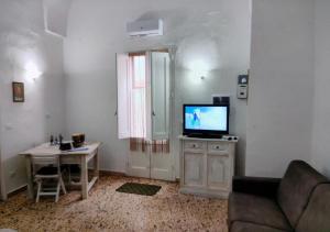 a living room with a television and a table at Antica dimora LUNA in Casarano