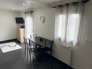a dining room with a table and chairs and a clock at Studio 2 - Loc Conciergerie in Trappes +6 photos