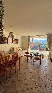 a living room with a bed and a table and chairs at Hermoso y Acogedor Departamento en el Centro Pucon in Pucón