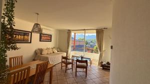a living room with a couch and a table with chairs at Hermoso y Acogedor Departamento en el Centro Pucon in Pucón +6 photos