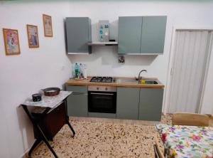 a small kitchen with green cabinets and a sink at Antica dimora LUNA in Casarano +11 photos