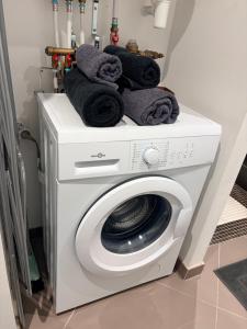 a washing machine with towels on top of it at Studio 2 - Loc Conciergerie in Trappes