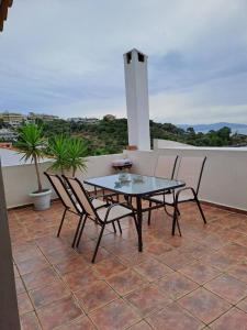 a patio with a table and chairs on a roof at CRYSTAL BAY in Paleo Tsifliki