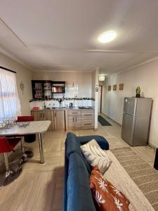 a living room with a blue couch and a kitchen at Seabreeze Accommodation in Lüderitz