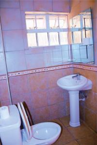 a bathroom with a toilet and a sink at Orchard Manor in Nairobi