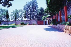 a brick walkway with a fence and aicked yard at Orchard Manor in Nairobi