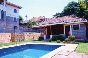 a house with a swimming pool in front of a house at Orchard Manor in Nairobi