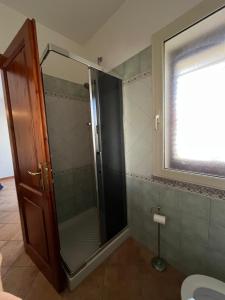 a shower with a glass door in a bathroom at Casa FLORE in Orosei +25 photos