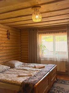 two beds in a room with a window at Садиба Людмила in Pilipets
