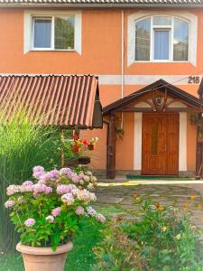 a house with a yard with flowers in front of it at Садиба Людмила in Pilipets