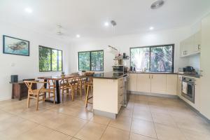 a kitchen and dining room with a table and chairs at Curlew Cove in Airlie Beach