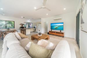 a living room with a white couch and a table at Curlew Cove in Airlie Beach