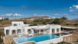 an aerial view of a white house with a swimming pool at Margi Villas in Mikonos