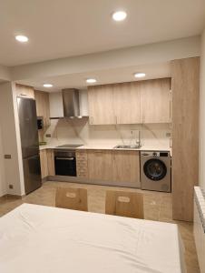 a kitchen with wooden cabinets and a sink and a dishwasher at Apartamentos Elvira Valderrobres in Valderrobres +8 photos