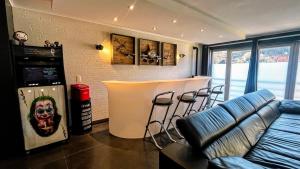 ein Wohnzimmer mit einer Bar mit Hockern in der Unterkunft Le Clos E in Theux