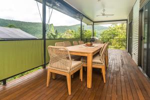 a wooden table and chairs on a deck at Curlew Cove in Airlie Beach