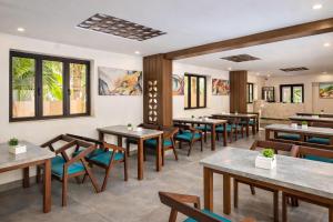 a restaurant with wooden tables and blue chairs at Hotel Centro in Calangute +1 photo