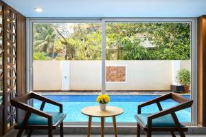 a pool view from a room with two chairs and a table at Hotel Centro in Calangute
