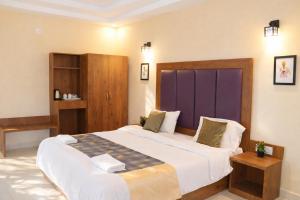 a bedroom with a large bed and a purple door at Hotel Centro in Calangute