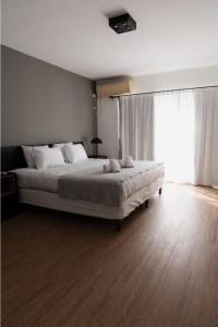 ein Schlafzimmer mit einem großen Bett und einem großen Fenster in der Unterkunft Form Hotel in Zárate + 7 Fotos