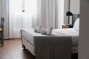 ein Schlafzimmer mit einem Bett, auf dem zwei Handtücher liegen in der Unterkunft Form Hotel in Zárate