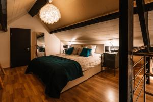 ein Schlafzimmer im Dachgeschoss mit Bett und Kronleuchter in der Unterkunft Le Clos E in Theux