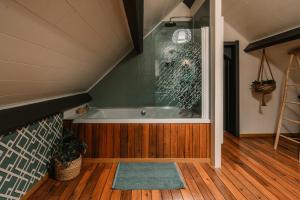 ein Badezimmer mit Badewanne und Glasfenster in der Unterkunft Le Clos E in Theux