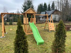 a playground with a green slide in a yard at ADAM-OASIS in Borzont