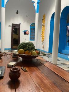 a bowl of watermelon and other fruit on a wooden floor at Riad mama aicha in Asilah