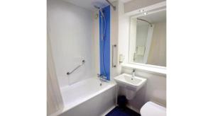 a bathroom with a sink and a tub and a toilet at Travelodge Widnes in Widnes