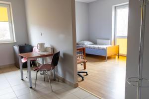 a room with a table and chairs and a bed at Dom Studenta PANS - Akademik, Hostel in Przemyśl