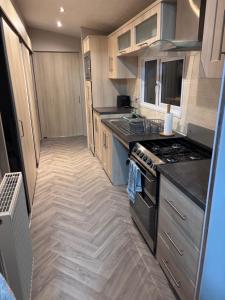 a kitchen with a stove and a counter top at ty newydd leisure park in Brynteg