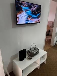 a white table with a television on a wall at Skadar Lake Stone House in Podgorica