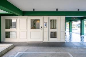 a building with white doors and green walls at Maestro St Lazar Apartments in Larnaca