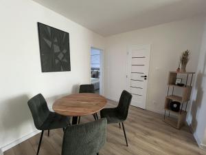 a dining room with a wooden table and chairs at Apartmán LÝRA Trenčín in Trenčín