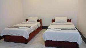 two beds sitting next to each other in a room at Pakbeng Backpackers in Pakbeng +8 photos