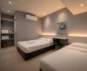 a hotel room with two beds and a desk at De UPTOWN Hotel @ P.J. 222 in Petaling Jaya