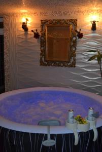 a bath tub in a room with a mirror at Traditional Log Cabin next to Harry Potter Studios in Kings Langley +18 photos