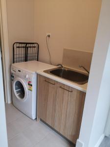 a kitchen with a sink and a washing machine at Cosy Private Modern Flat in Epping