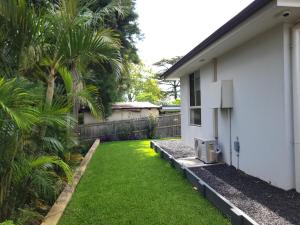 a yard next to a white house with a green lawn at Cosy Private Modern Flat in Epping