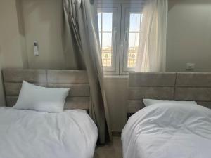 a bedroom with two white beds and a window at Sharm Glow Villa in Sharm El Sheikh +10 photos