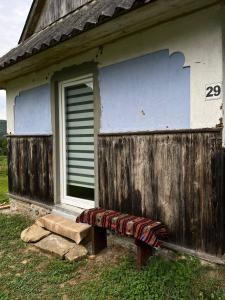 a bench sitting outside of a house with a window at Дідова Хата in Sheshory