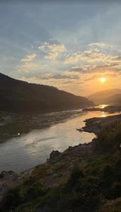 a view of a river with the sunset in the background at Pakbeng Backpackers in Pakbeng