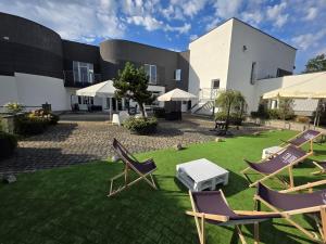 a group of chairs sitting on a lawn in front of a building at Nowe apartamenty SOLAR, Padel & Tenis, Parking, Blisko centrum in Bielsko-Biała