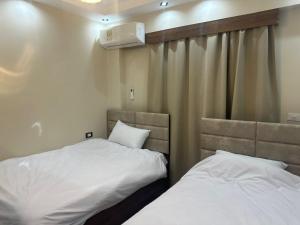 two beds in a small room with a curtain at Sharm Glow Villa in Sharm El Sheikh